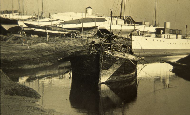  Barge HYACINTH in nearly her last resting place at Tollesbury late 1930s. The remains were removed to build Tollesbury Marina. Motor yacht ALDIC on the right. 
Cat1 Barges-->Pictures Cat2 Tollesbury-->Woodrolfe Cat3 Yachts and yachting-->Motor